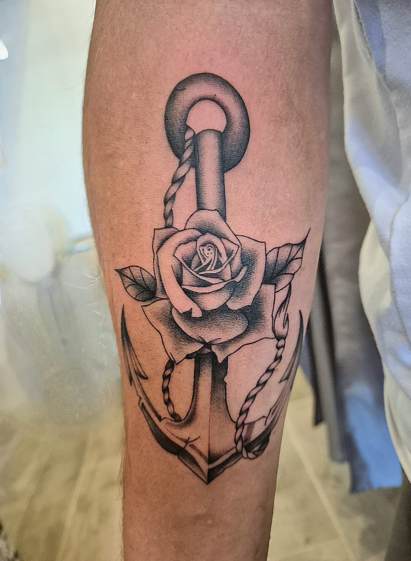 Ancre et rose tatouées sur le mollet, tatouage de style traditionnel