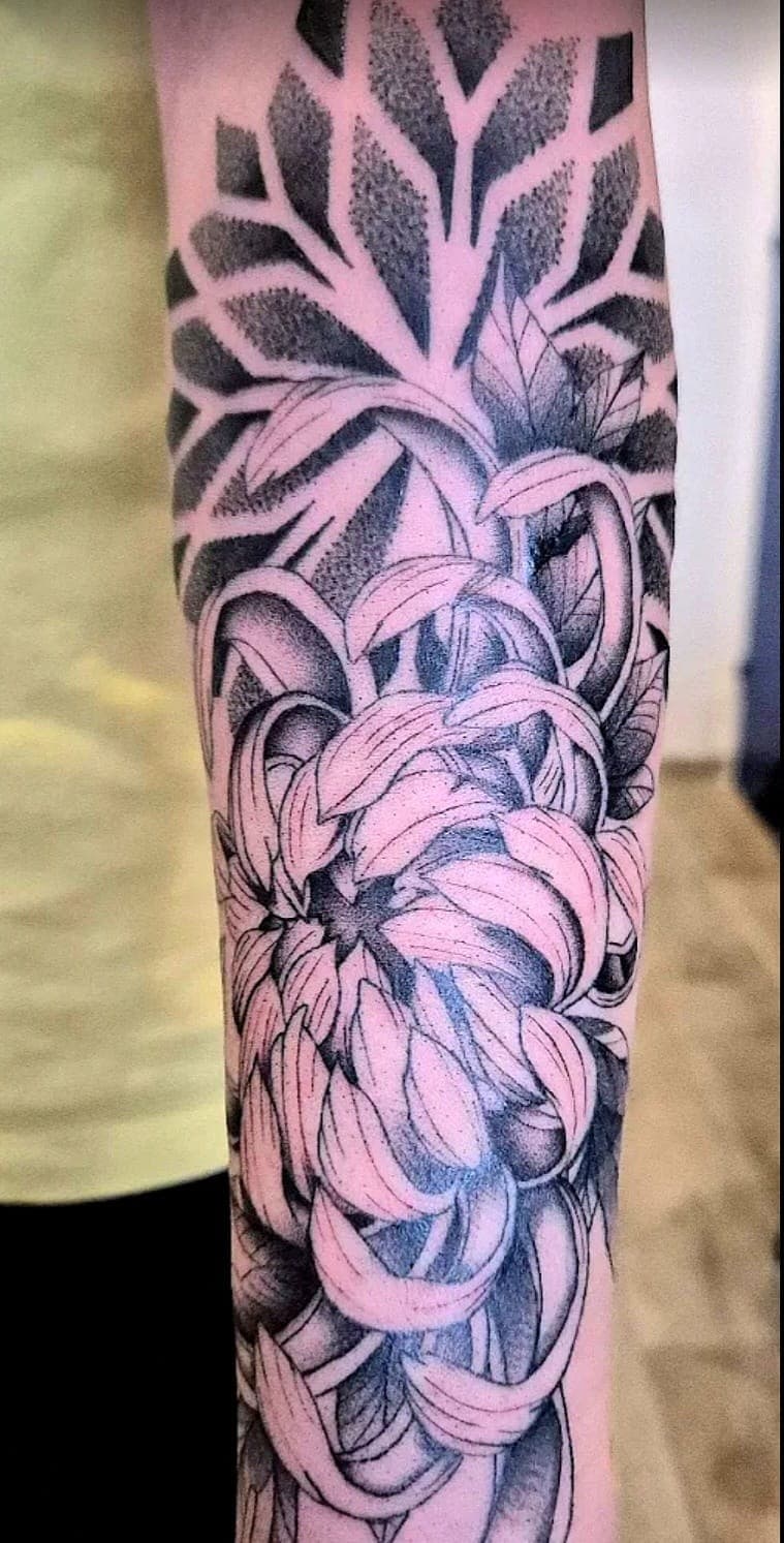 Chrysanthèmes japonais tatoués en dotwork sur le bras, au salon de Gruissan